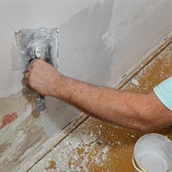 Man smoothing a wall with a trowel