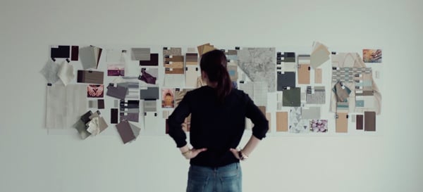  Interior Designer, Aga Artka, looking at flat lays of Inpro products, color swatches, and materials.