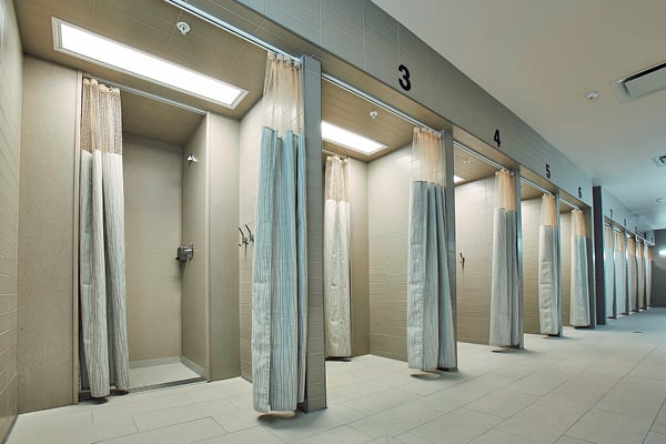 A row of shower stalls with changing areas before each shower.