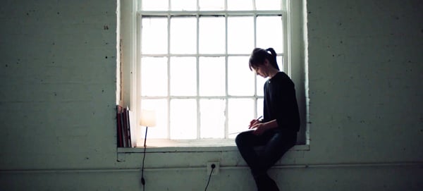 Interior Designer, Aga Artka, sitting on a windowsill sketching elements of Inpro’s 2020 centered collection based on what inspires her.