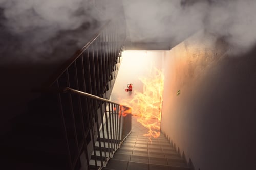 A stairwell with fire coming up the stairs.