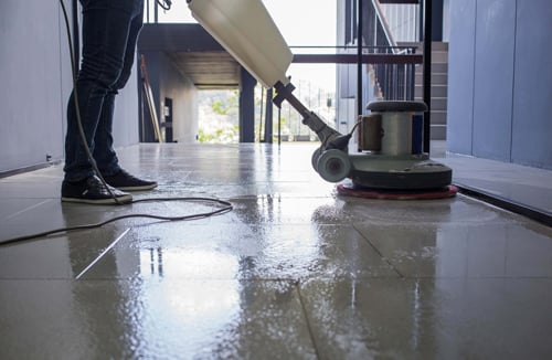 A person power washing a hallway.