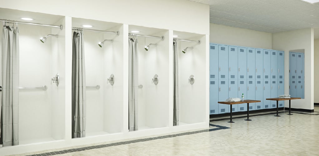 A locker room with individual shower stalls.