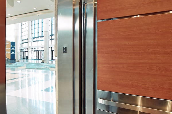 Looking out from an elevator cab into a school lobby.