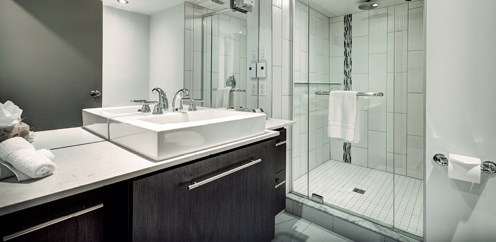 A prefabricated bathroom with a walk in shower and raised sink.