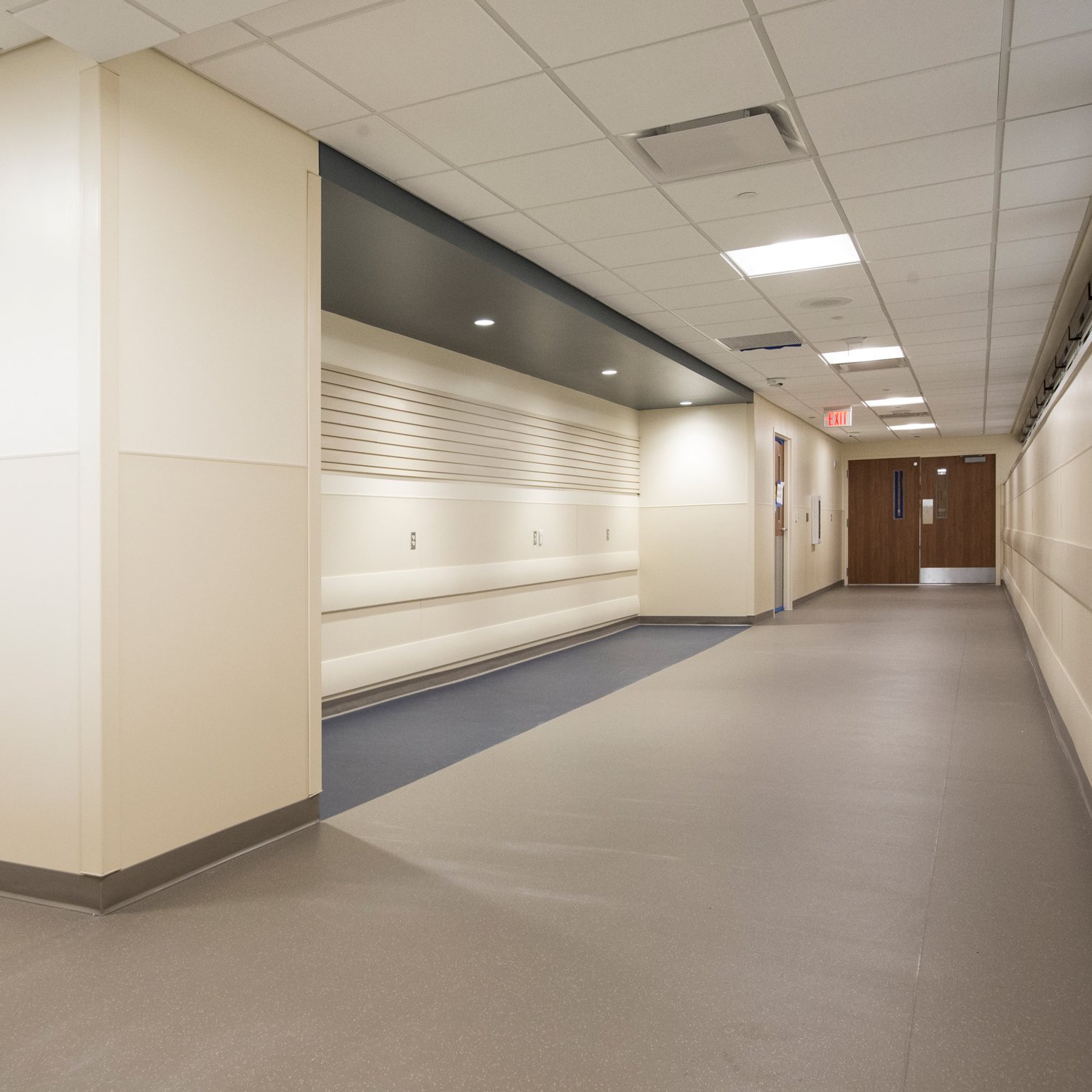 Beige rigid vinyl sheet with matching trim in corridor